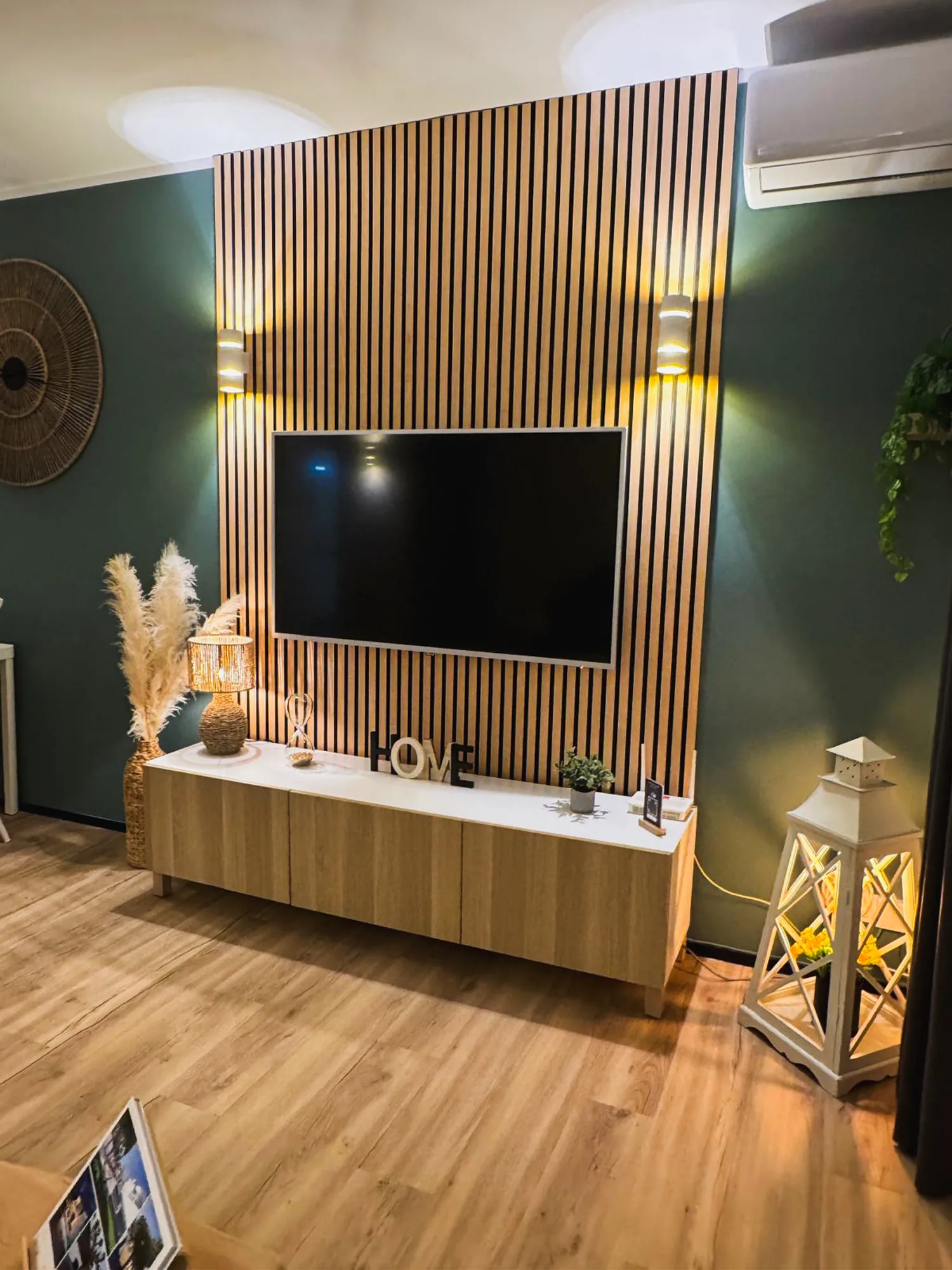 Mur TV habillé de bois dans le salon de l'appartement
