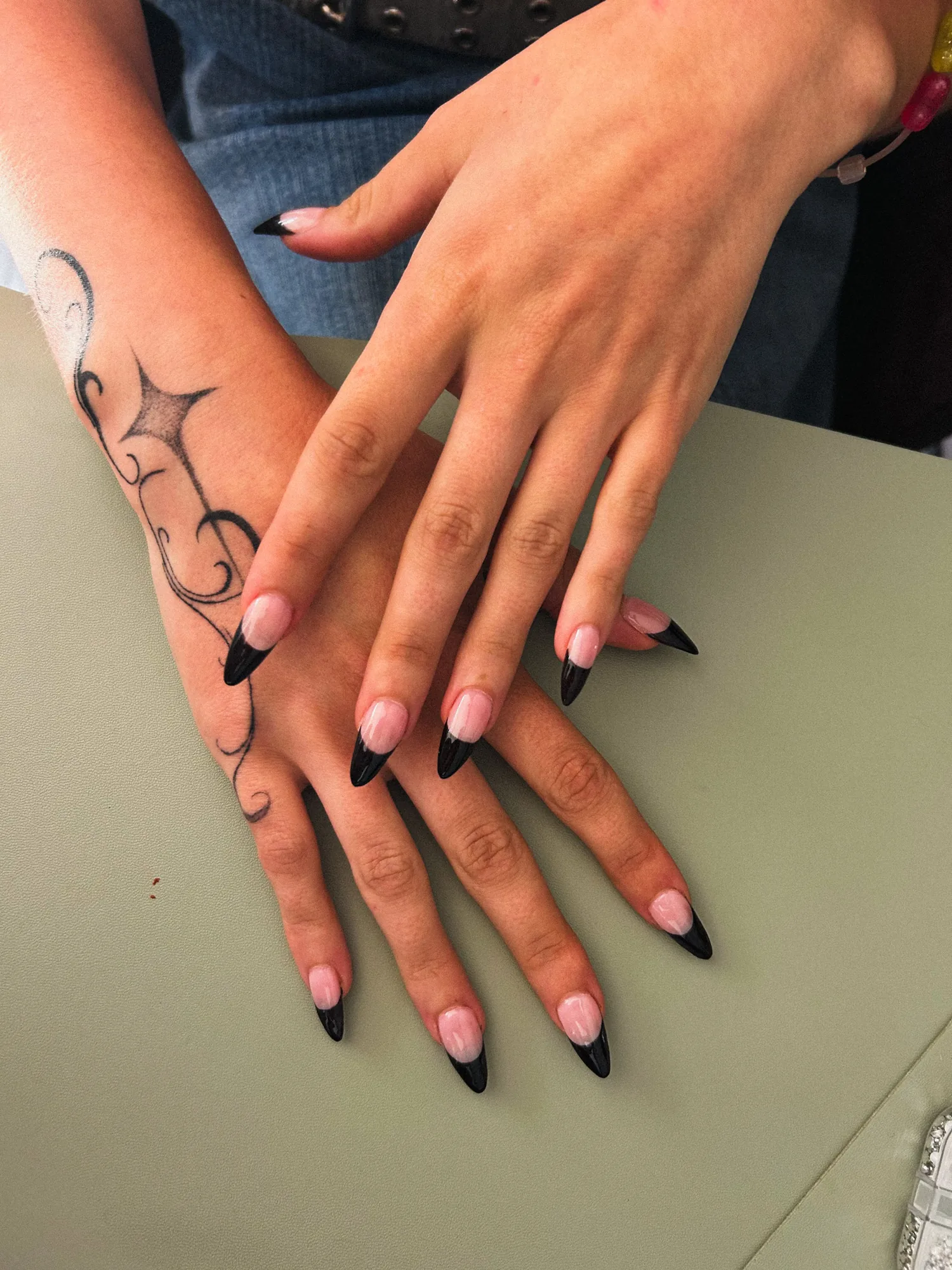 Manucure almond en french tip noir glossy, gros plan sur les deux mains